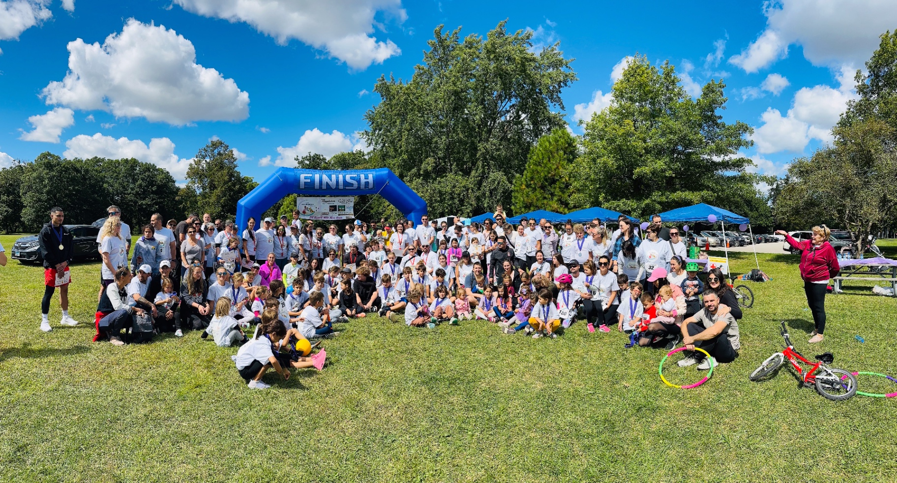 Large group photo of participants at the finish arch