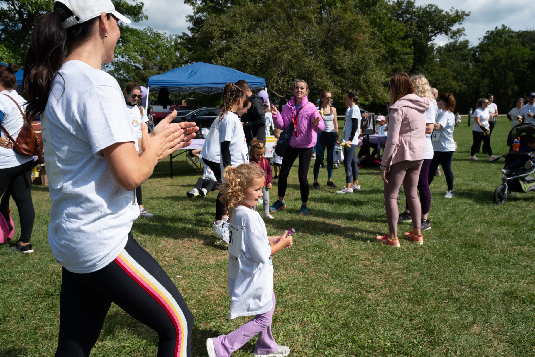 Volunteers cheering on a young runner