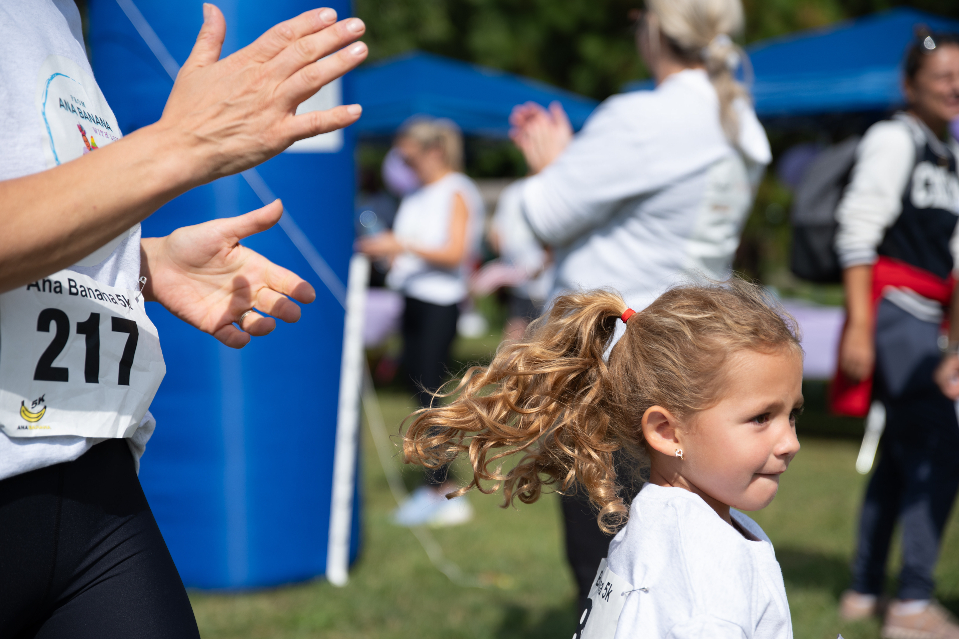 A young runner being cheered on at the finish line